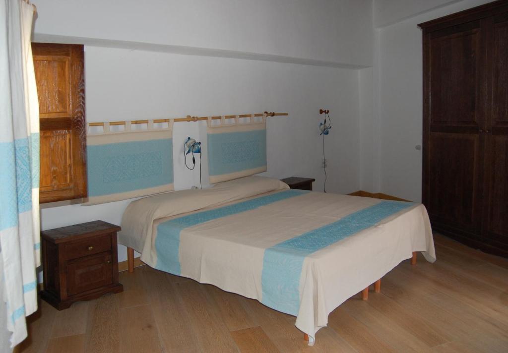 una camera con letto e pavimento in legno di Rifugio Di Galte a Galtellì