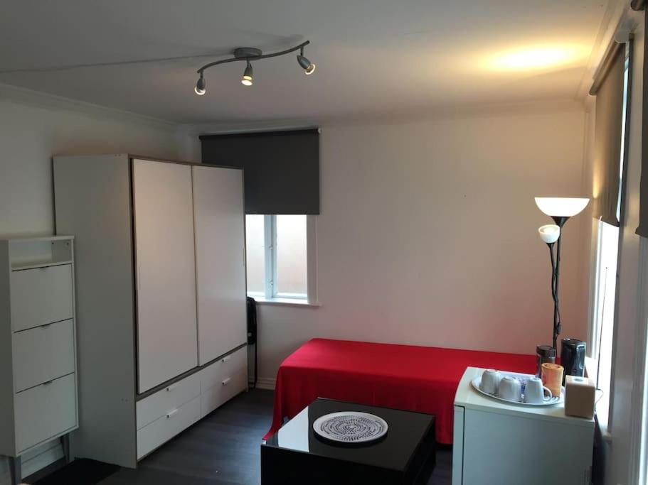 1 dormitorio con cama roja y armario blanco en A Double Room - Not a complete apartment - Perfect Location for exploring the City by walking, en Bergen