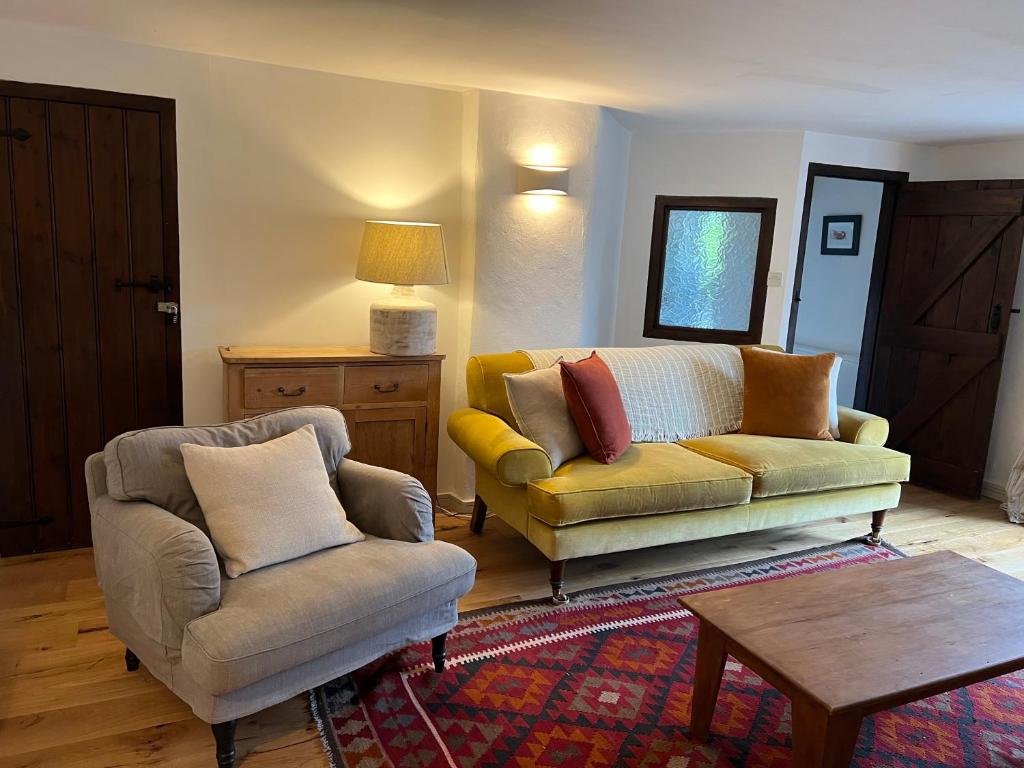 a living room with a couch and a chair at Bay Tree Barn in Truro