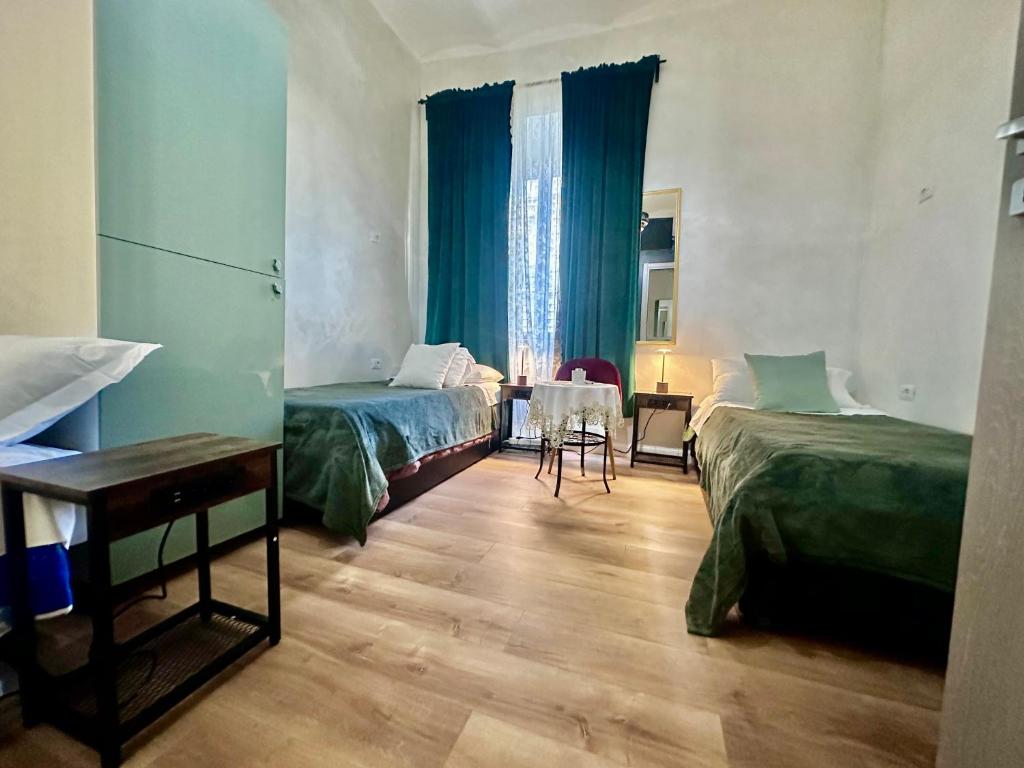 ローマにあるRomân Holidaysのベッド2台とテーブルが備わるホテルルームです。