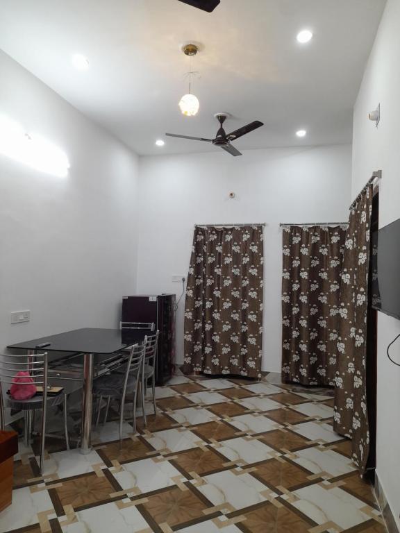 una sala da pranzo con tavolo e ventilatore a soffitto di Gunjan Cottage a Deoghar