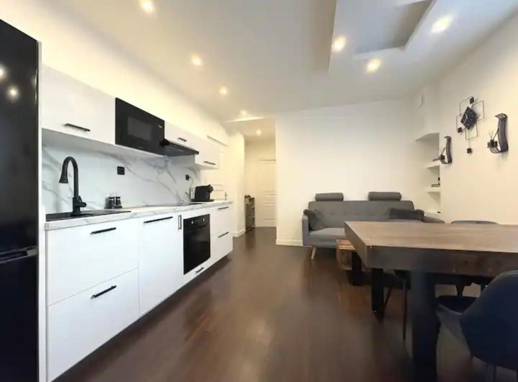 une cuisine et un salon avec une table et un canapé dans l'établissement Le Charmant Grenoble, à Grenoble