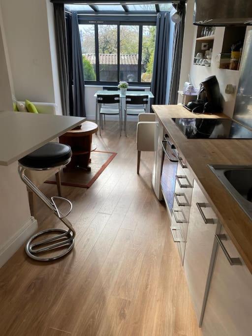 une cuisine avec un comptoir et une salle à manger avec une table dans l'établissement Appartement avec jardin Duchaffault 44100Nantes, à Nantes