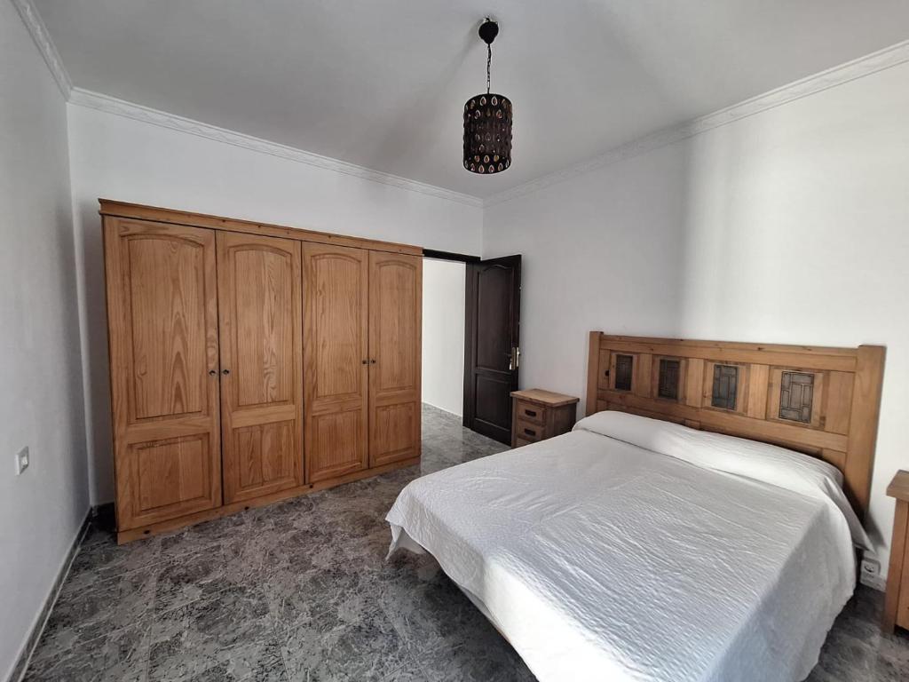 um quarto com uma cama grande e armários de madeira em Casa Paraiso em San Bartolomé