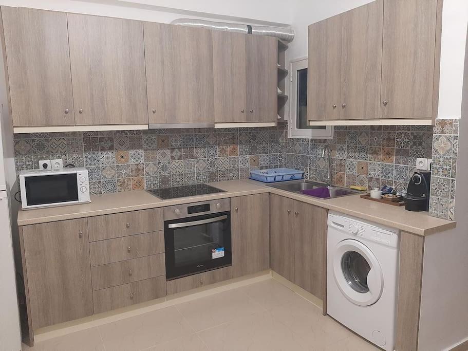 a kitchen with a washing machine and a microwave at Modern apartmen in Athina in Athens