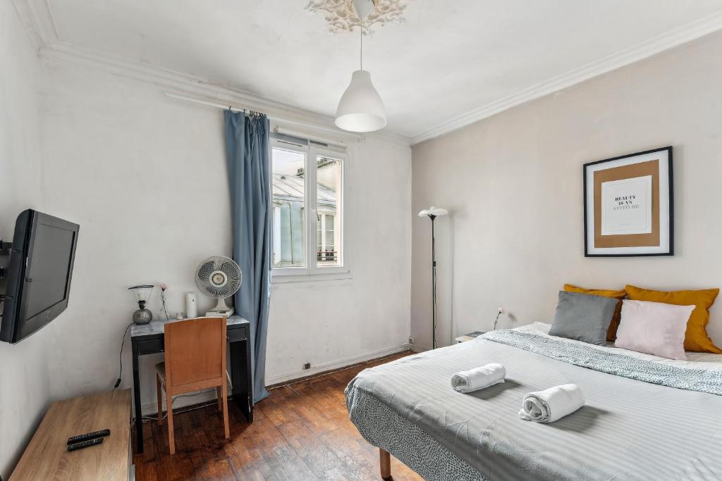 a bedroom with two beds and a desk in it at Wonderful apartment close Champs-Elysées in Paris