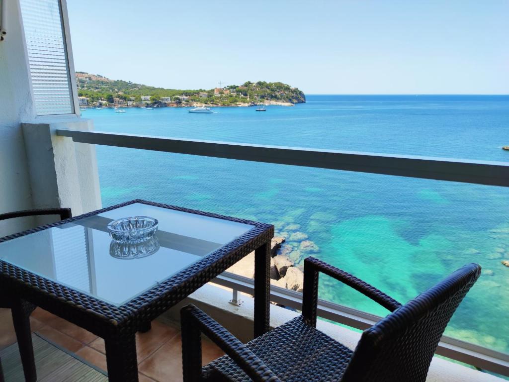 a table and two chairs on a balcony with the ocean at Mediterranean sea view apartment in Santa Ponsa