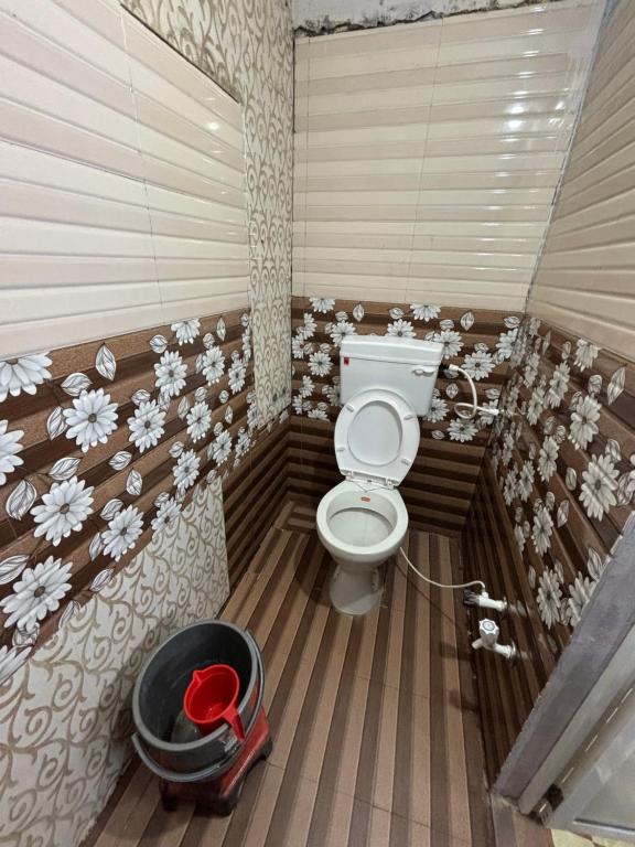 La salle de bains est pourvue de toilettes et d'un seau. dans l'établissement sun guest house 2, à Ujjain