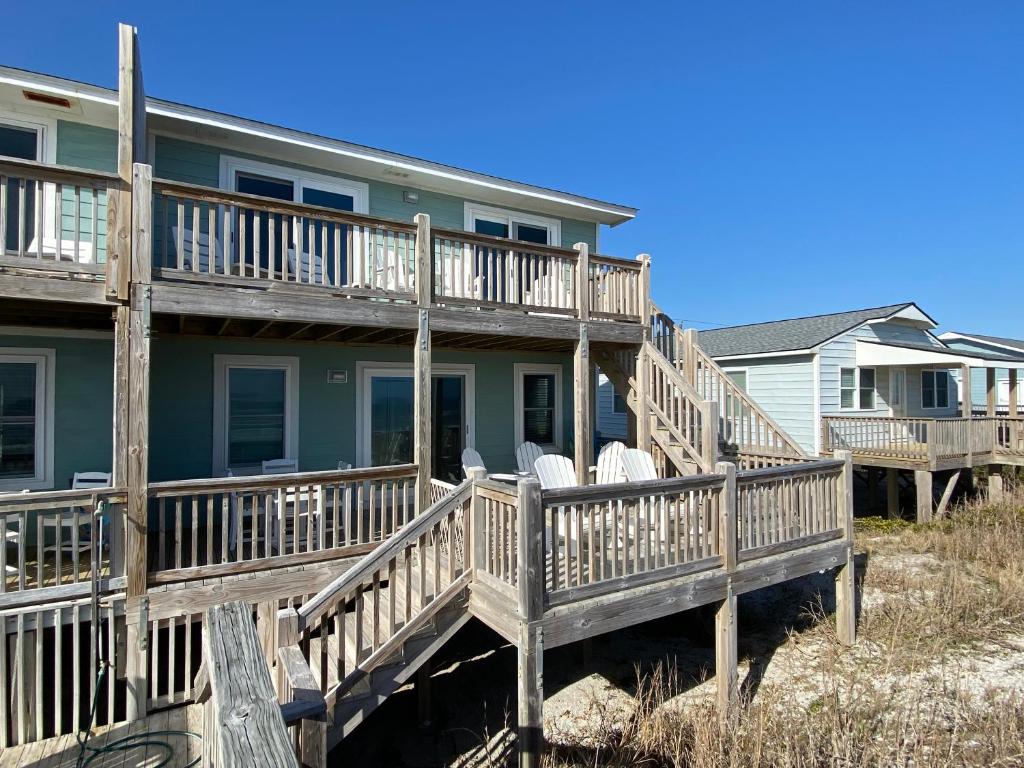 een huis met een terras op het strand bij 2 if by Sea- East Unit in Emerald Isle