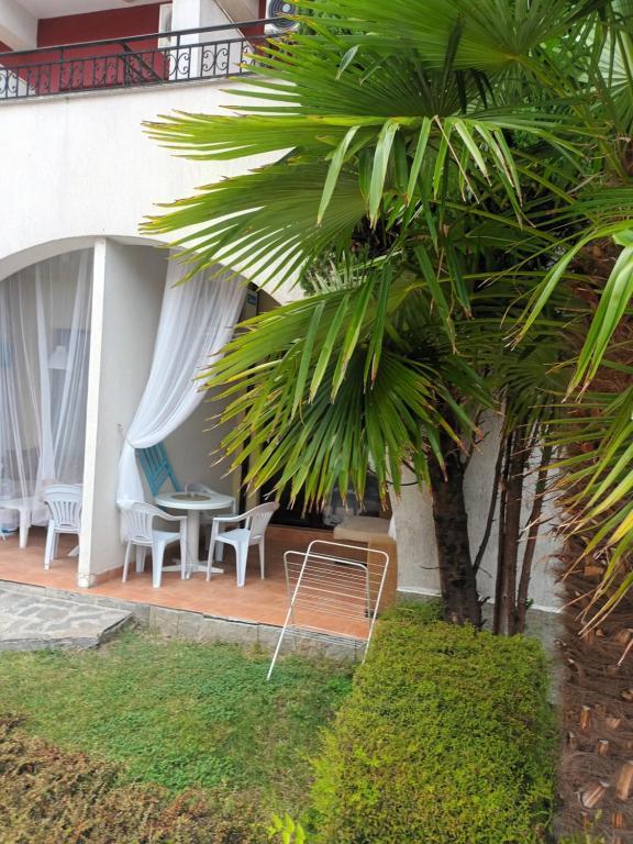 um resort com uma palmeira, uma mesa e cadeiras em APARTMENT STUDIO DELUXE MARINA CAPE 4 stars resort 33 5 em Aheloy