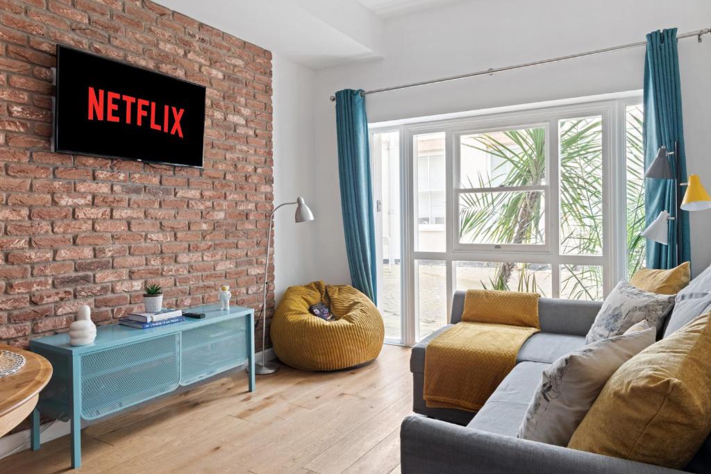 ein Wohnzimmer mit einer Couch und einer Ziegelwand in der Unterkunft Urban Elegance - 2 Bed Luxury City Retreat in Nottingham