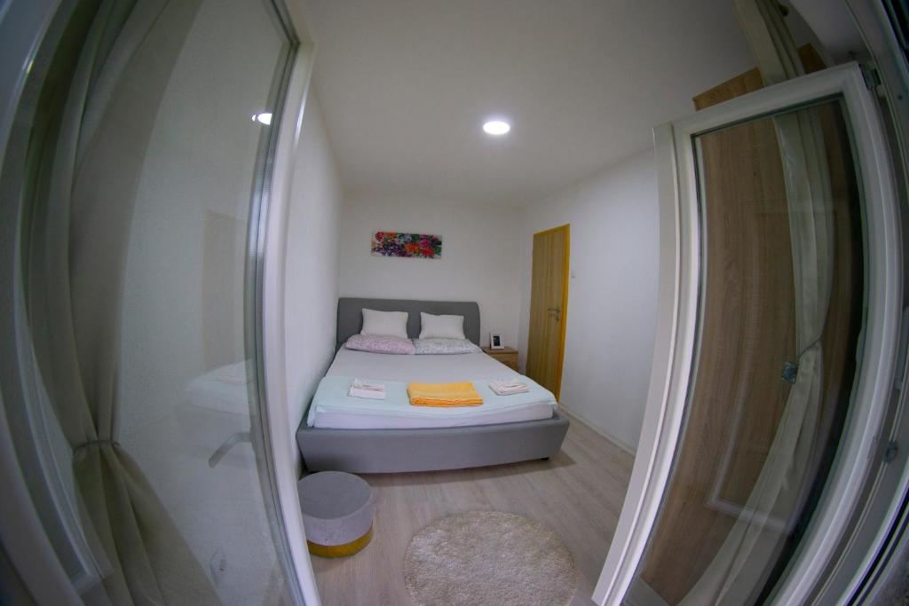 a small bedroom with a bed and a shower at UKROPINA APARTMENTS in Trebinje