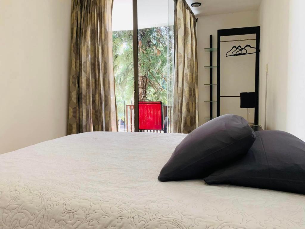 een slaapkamer met een groot bed met een kussen erop bij Alojamiento tres pinos in Yelateni