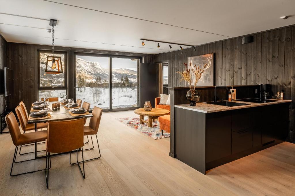 a kitchen and dining room with a table and chairs at Helt ny leilighet i Hemsedal, rett ved Fyri Resort - Ski inn - Ski out in Hemsedal