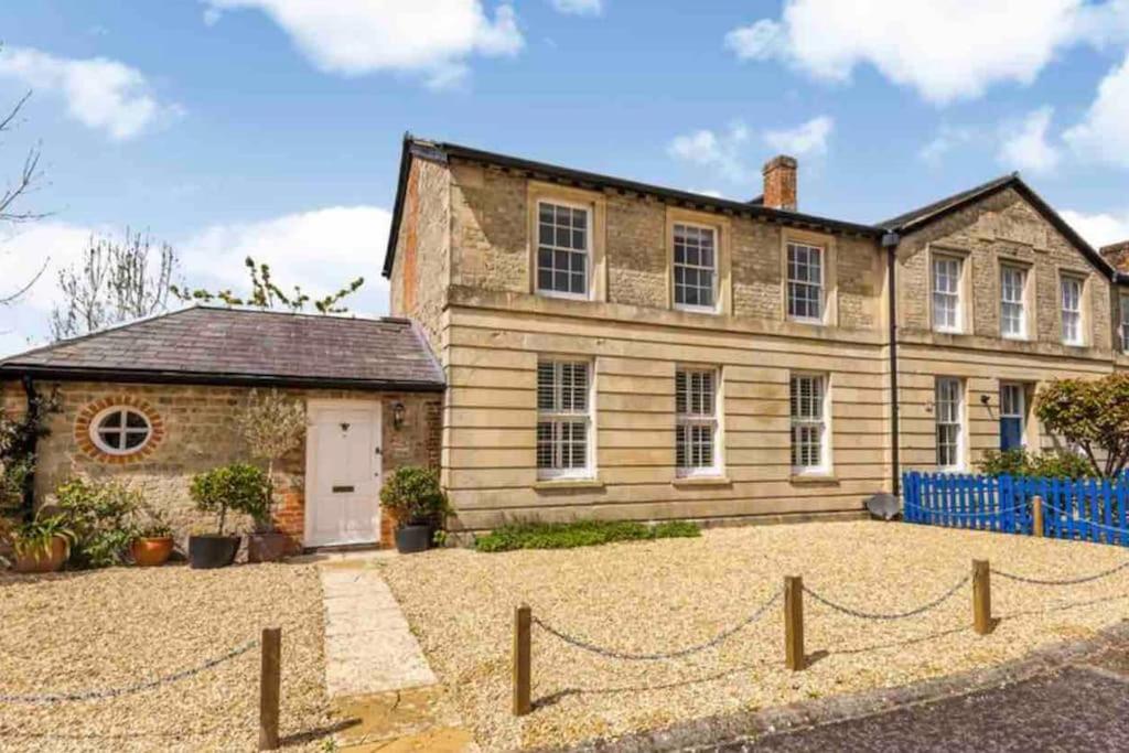 uma casa velha com uma cerca em frente em Large historic family home nr Longleat and Bath em Warminster