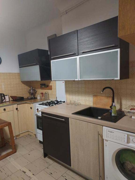Il comprend une cuisine équipée d'un évier et d'une cuisinière. four supérieur dans l'établissement 2-кімнатна квартира, à Varsovie