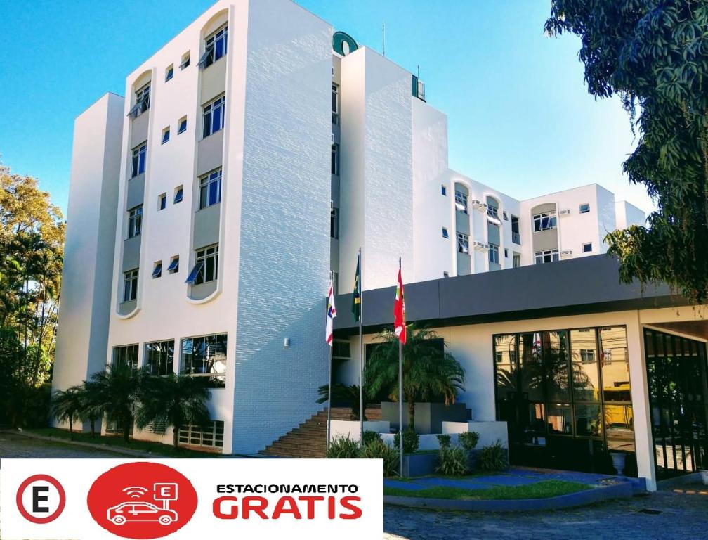 a white building with a flag in front of it at Brisamar Suite Hotel in Florianópolis
