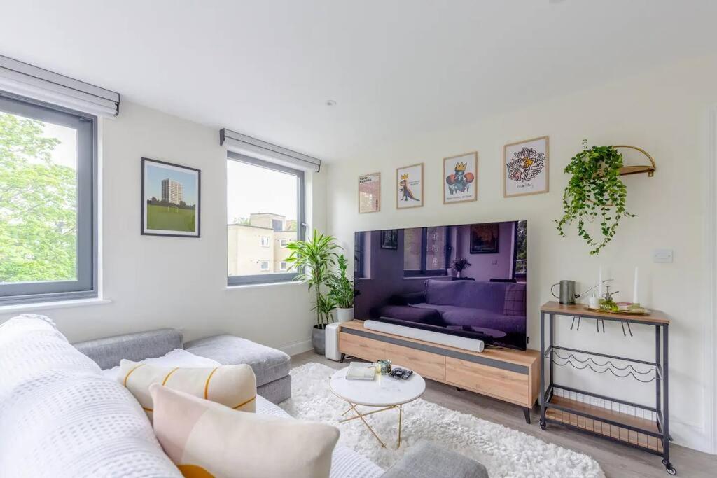 a living room with a couch and a table at Modern & Bright 2 Bed with Pvt Balcony in Islington in London