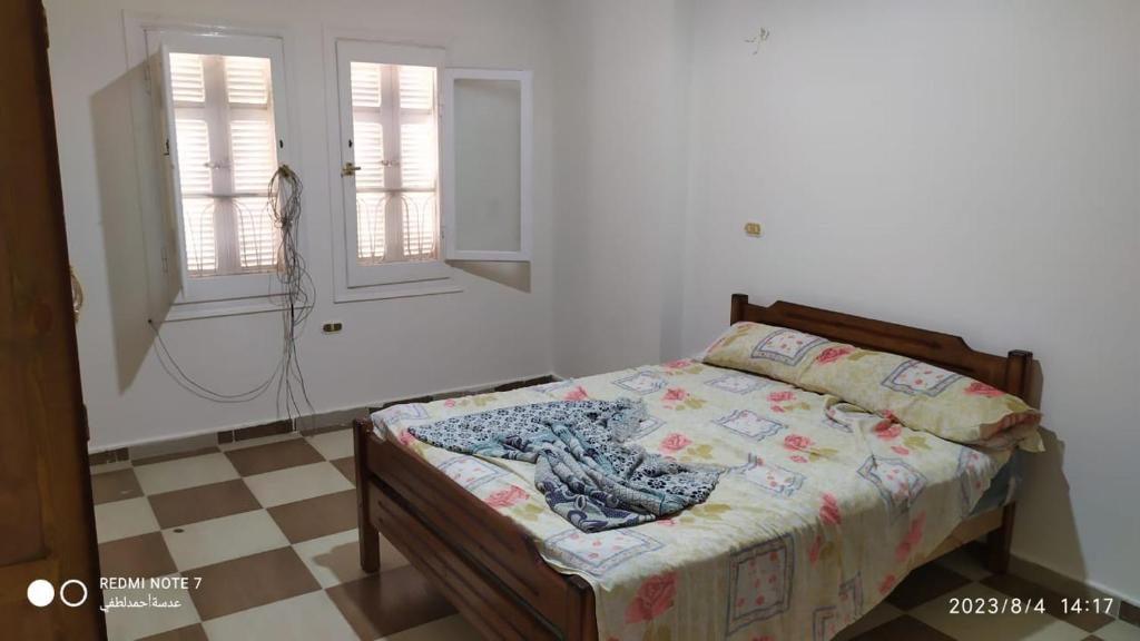 a bedroom with a bed and two windows at Luxry flat in matrouh in Marsa Matruh