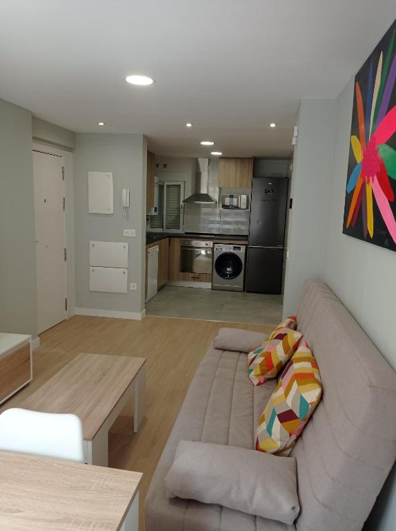 Una sala de estar con un sofá y una cocina. en A orillas del Duero, en Soria