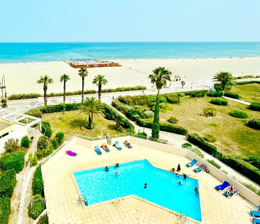 une vue aérienne d'une piscine et de la plage dans l'établissement APPARTEMENT VUE PLONGEANTE LES PIEDS DANS L'EAU, PISCINE et MER, à Canet