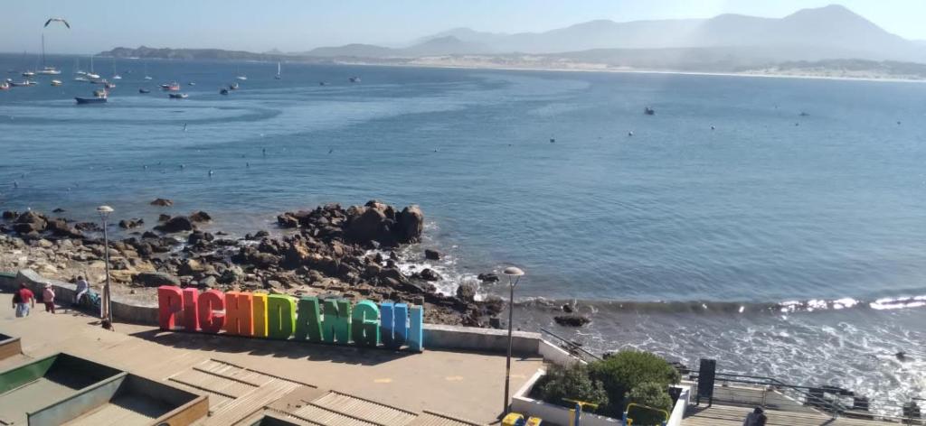 una playa con un montón de gente en el agua en Twin Brothers Pichidangui en Pichidangui