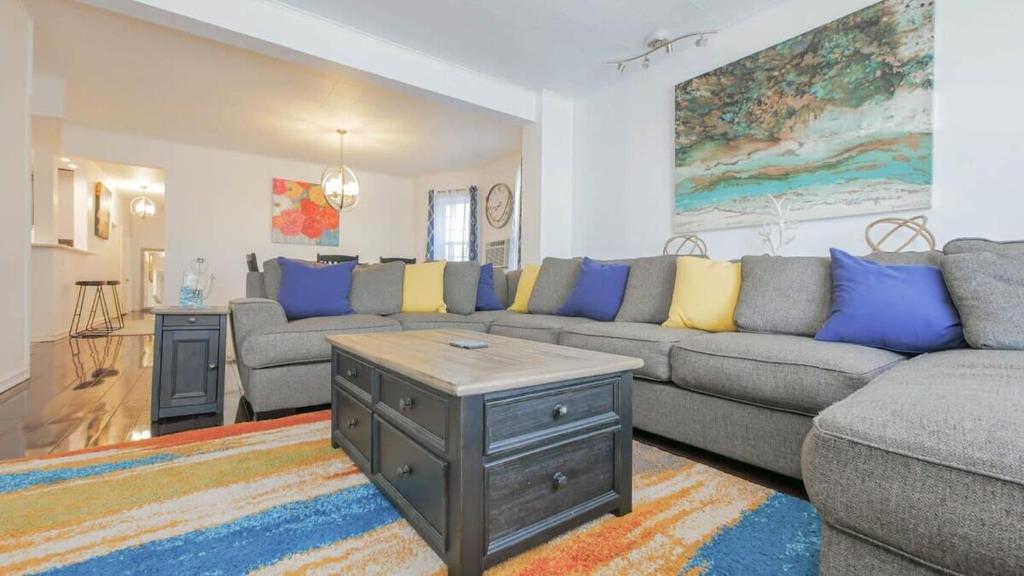 a living room with a couch and a table at Escape to Raleigh Ave - Steps from the Beach in Atlantic City