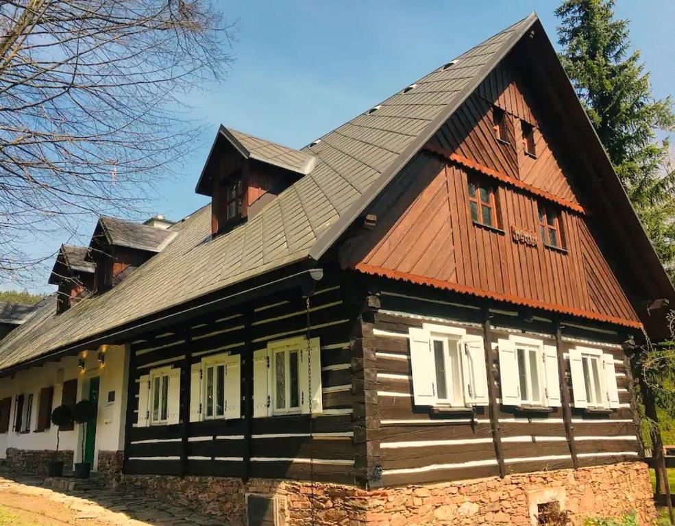 Casa de madera grande con techo marrón en Dům U Dvou Líp / The Two Lime Trees, en Mohren