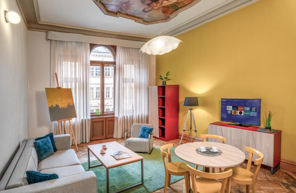ein Wohnzimmer mit einem Tisch und einem TV in der Unterkunft Art House Apartments by Adrez in Prag
