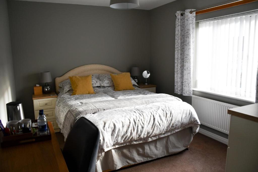 Un dormitorio con una cama con almohadas amarillas y una ventana en Meadowsweet House, en Stockton-on-Tees