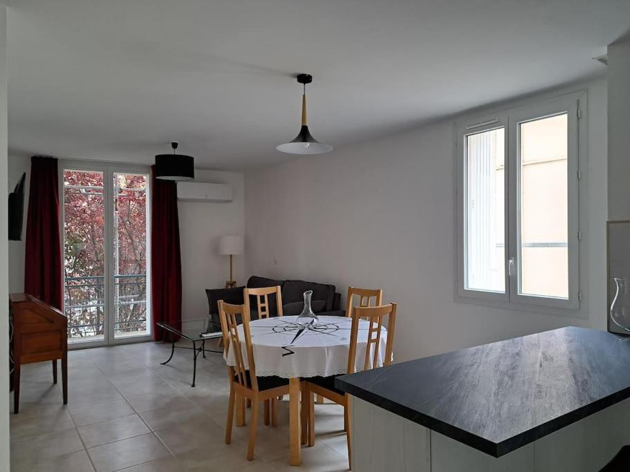 uma cozinha e sala de jantar com mesa e cadeiras em Grand T2 Clim & Fibre - centre universités Béziers em Béziers