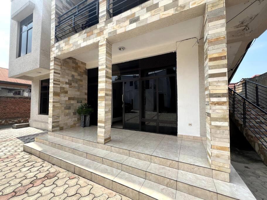 a building with glass doors on a patio at Alma Residence Apartment in Rubavu