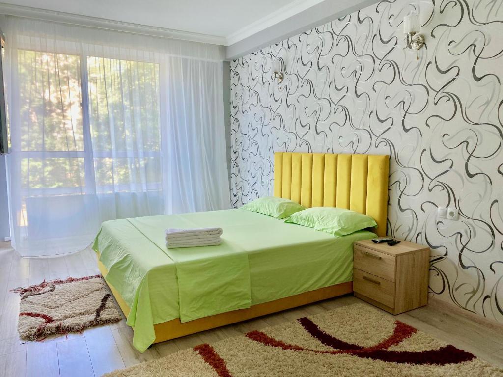 1 dormitorio con 1 cama con cabecero amarillo en Apartament comfort Centru, en Chişinău
