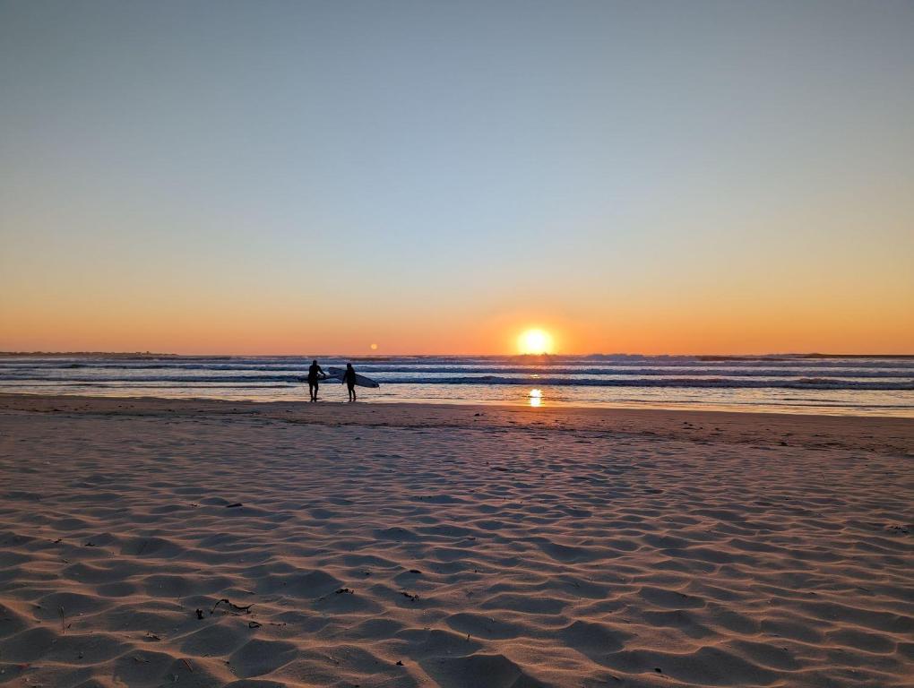 two people walking on the beach at sunset at Camping de Lanven in Plomeur