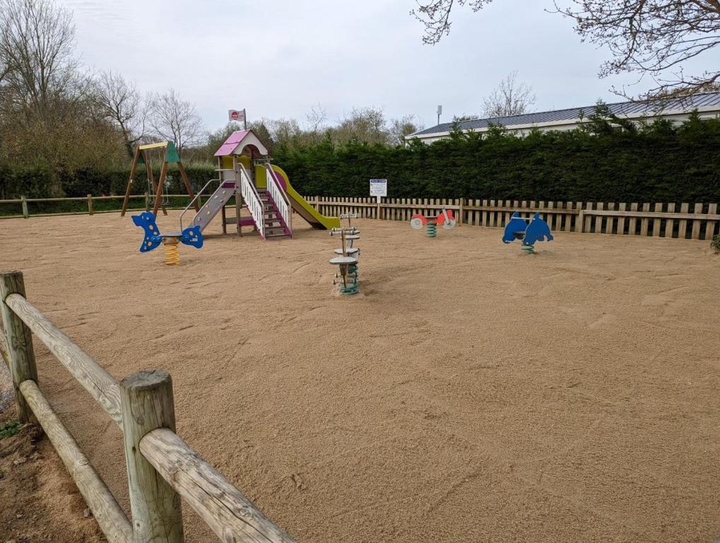a playground with slides and a play equipment at Camping de Lanven in Plomeur