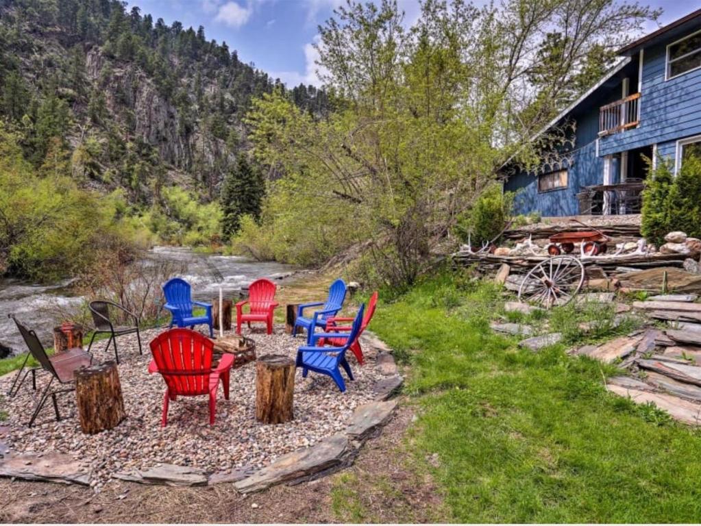 a group of chairs sitting on logs in a yard at Hygge House on the Creek in Rapid City