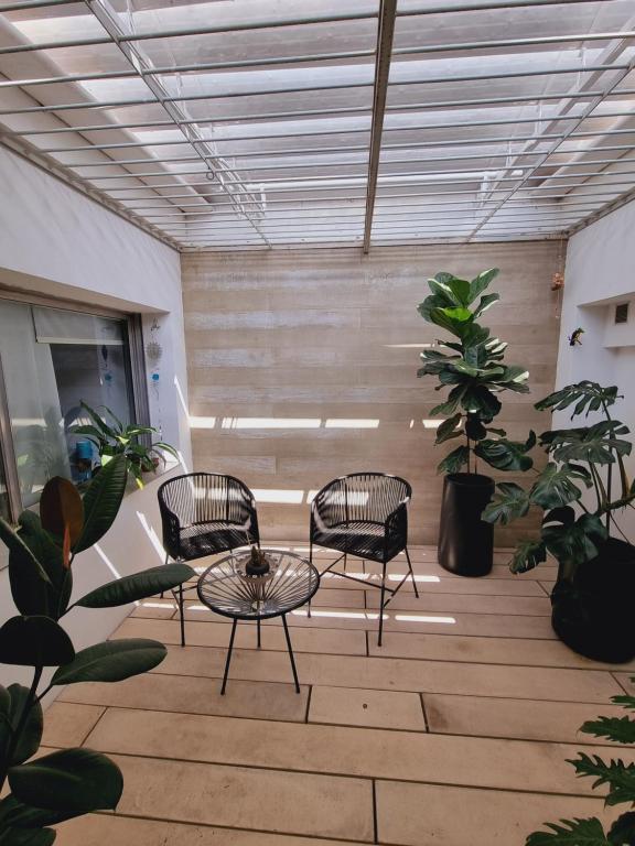 um quarto com três cadeiras e uma mesa e plantas em Habitación Córdoba Capital centro cerca de todo em Córdoba