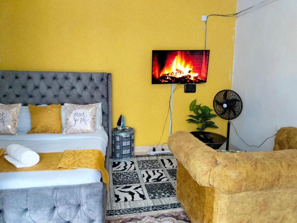 una camera con letto, divano e camino di Serenity Studio Nakuru CBD-WiFi-Ample Parking-Netflix-Budget Rates a Nakuru