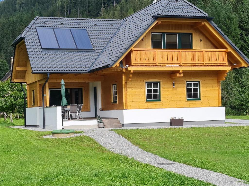 une maison avec des panneaux solaires en haut dans l'établissement Romantik Chalet Pretalhof, à Turnau