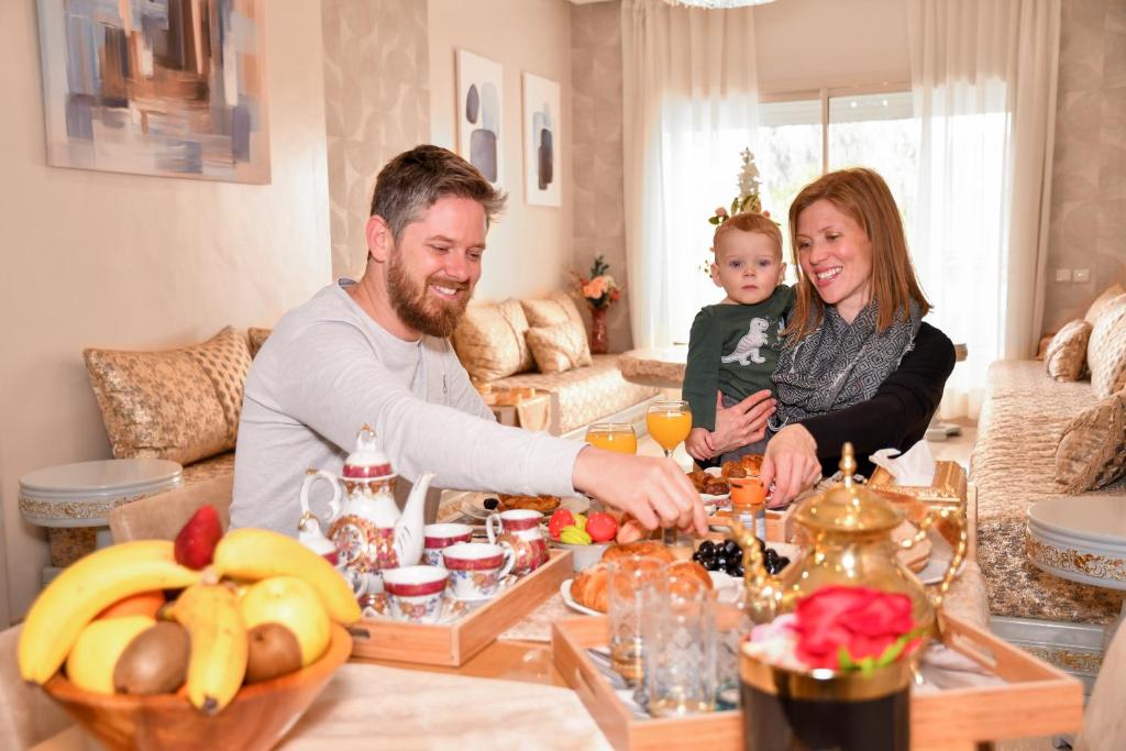 een groep mensen die rond een tafel in een woonkamer zitten bij Luxury Apartment Airport in Nouaseur