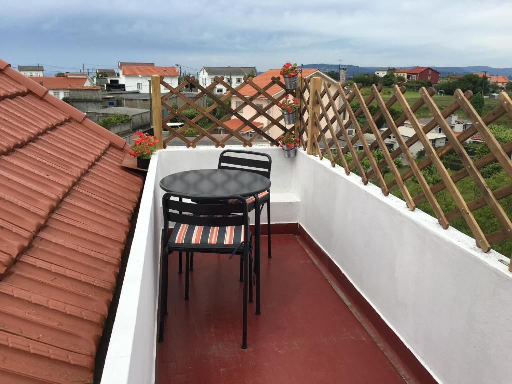 ein Paar Stühle auf einem Balkon in der Unterkunft Apartamento cerca playa 3 in Puentedeume
