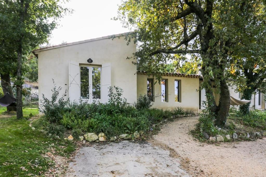 une maison blanche avec un arbre devant dans l'établissement Villa Lacoste Luberon piscine 4 ch 4 sdb (+ clim), à Lacoste