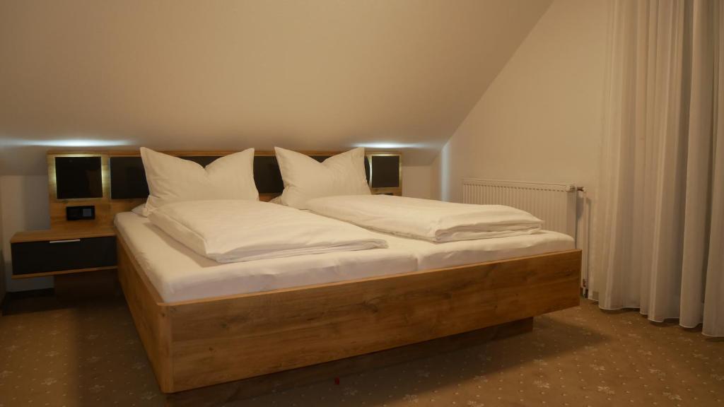 een slaapkamer met een bed met witte kussens bij Haus Thule in Carolinensiel