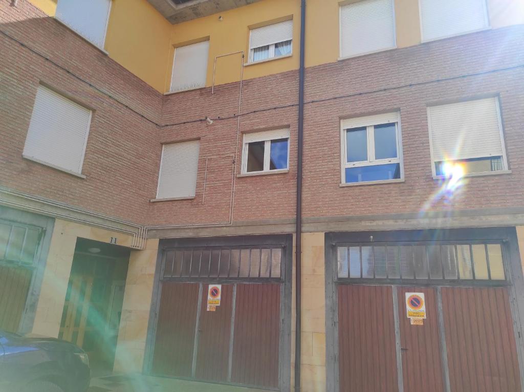 um edifício de tijolos com duas portas de garagem e janelas em Travesía de La Rioja em Casalarreina