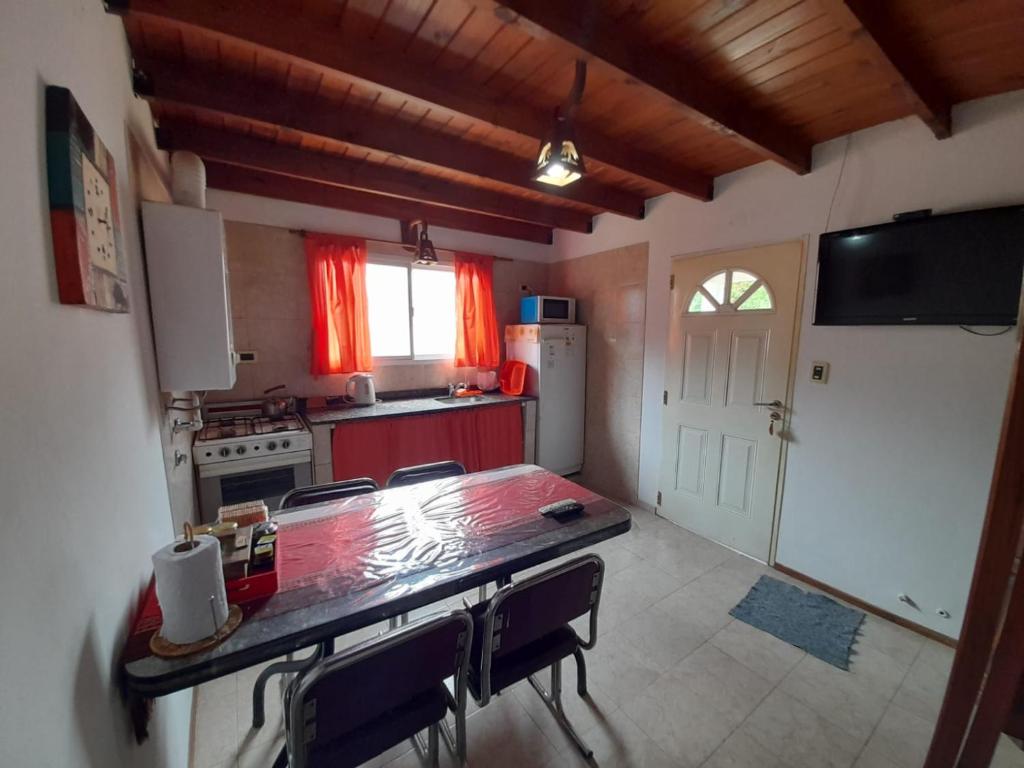 a kitchen with a table and chairs and a kitchen with a refrigerator at Departamentos Luci in Embalse