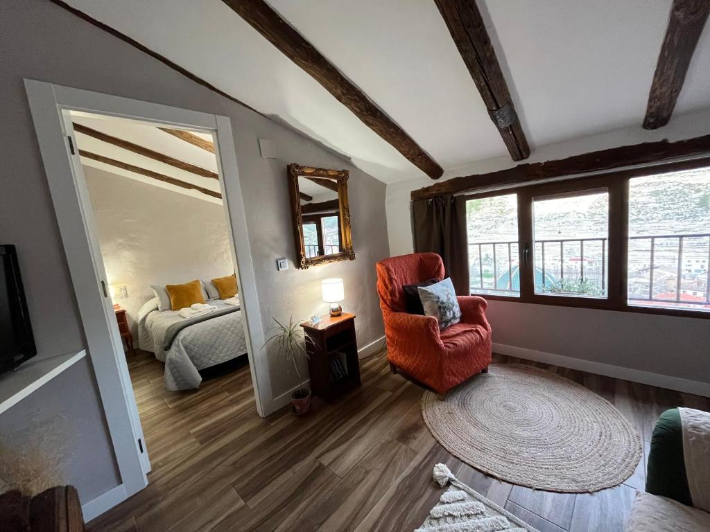 Cette chambre comprend un lit, une chaise et un miroir. dans l'établissement Casa rural abuela Gaspara, à Alcalá del Júcar