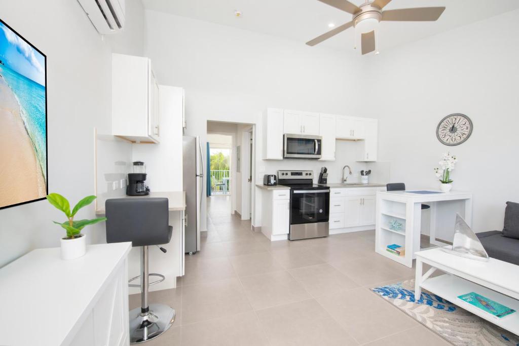 una cucina con armadi bianchi e un ventilatore a soffitto di Summertime Suites #53 a West Bay