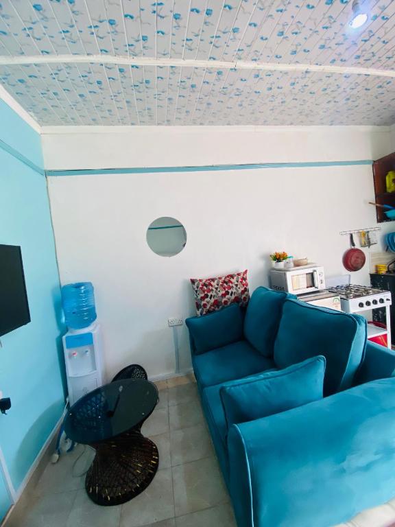 a living room with a blue couch and a table at Budget Studio. Nakuru CBD. Wifi. Spacious. Ample Parking in Nakuru