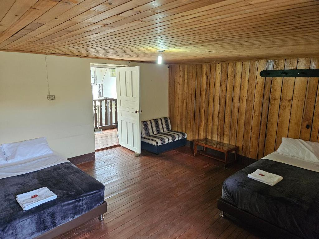 Habitación con 2 camas y sofá. en Casa Guicán, en Güicán