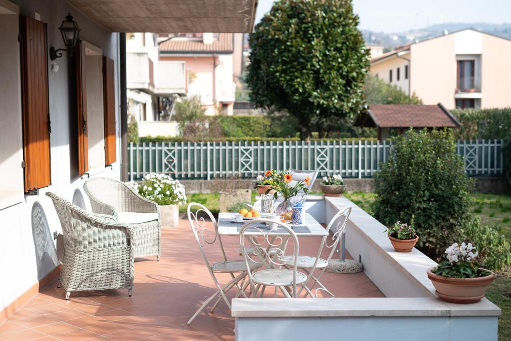 eine Terrasse mit einem Tisch und Stühlen auf einer Veranda in der Unterkunft Canevon Suite Apartment in Bardolino